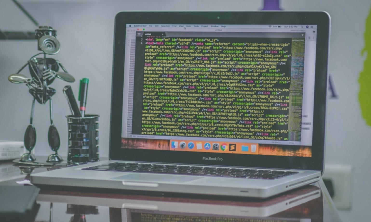 Developer working on mobile solution architecture at desk with multiple screens